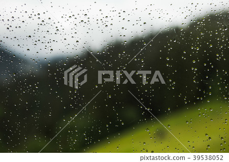 Raindrops of rain on glass of window of cottage 39538052
