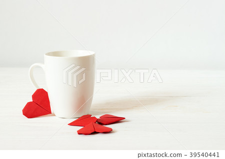 White cup and origami red hearts 39540441
