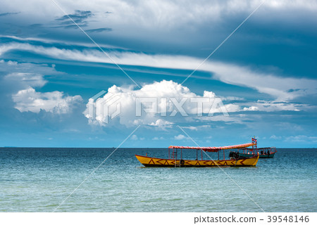 Yellow Longtail boat moored close to the beach Yellow Longtail boat moored close to the beach 39548146