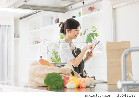Female lifestyle tablet operation in the kitchen 39548185