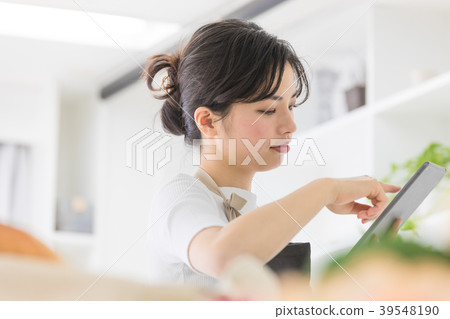 Female lifestyle tablet operation in the kitchen 39548190