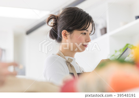 Female lifestyle tablet operation in the kitchen 39548191