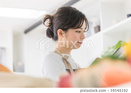 Female lifestyle tablet operation in the kitchen 39548192