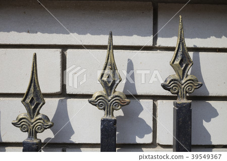 Three tops of a metal fence. 39549367