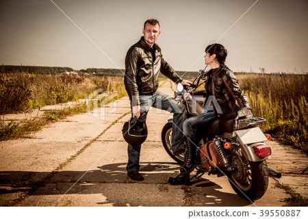 Bikers couple Man and woman near a motorcycle on the road 39550887