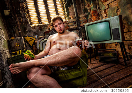 Fat man eating a hamburger sitting on a chair in the slums Fat man eating a hamburger sitting on a chair in the slums 39550895