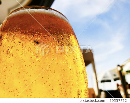 A glass of beer on a street cafe background. A glass of beer on a street cafe background. 39557752