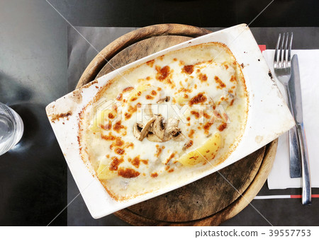 Potato and  mushrooms in a creamy sauce and cheese 39557753