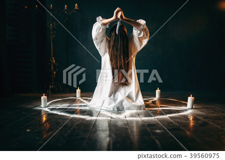 Woman with knife sitting in pentagram circle Woman with knife sitting in pentagram circle 39560975