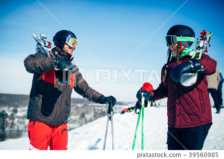 Male and female skiers poses with skis and poles Male and female skiers poses with skis and poles 39560985