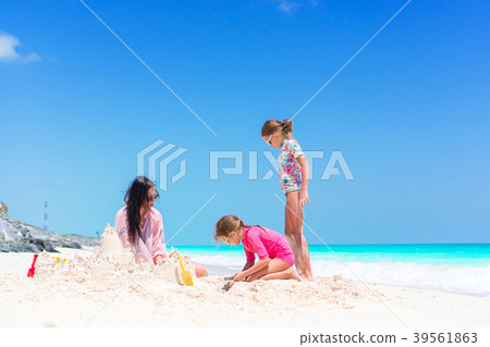 Family making sand castle at tropical white beach 39561863