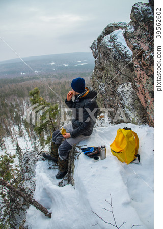 Man hiker have a rest at mountain top, drinking Man hiker have a rest at mountain top, drinking 39562602