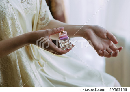 the girl sprinkles herself with perfume the girl sprinkles herself with perfume 39563166