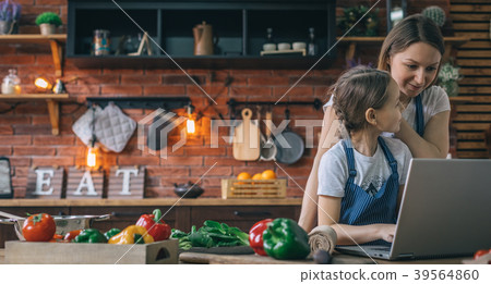 Mother and girl using laptop on kitchen Mother and girl using laptop on kitchen 39564860