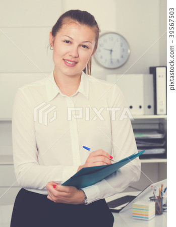 Young female is signing agreement papers of financial nature 39567503