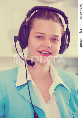 Office worker woman is working at a computer and talking by headset with client 39567520