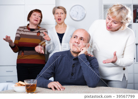 Mature male is sitting upset and woman is apologizing 39567799