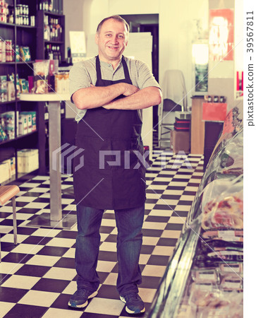 Male seller posing with wursts in butchery 39567811