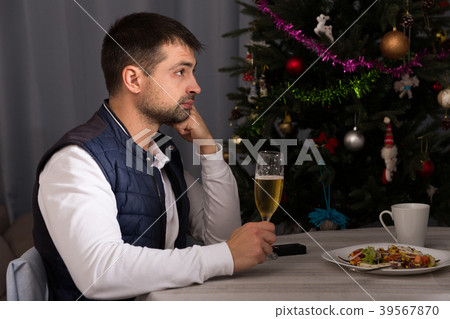 Young man celebrating New Year, having dinner, watching tv Young man celebrating New Year, having dinner, watching tv 39567870
