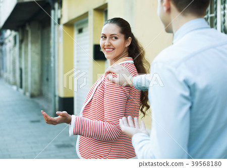 man chasing pleased smiling beautiful brunette woman man chasing pleased smiling beautiful brunette woman 39568180
