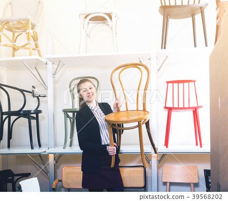 Woman seller suggesting wooden chairs 39568202