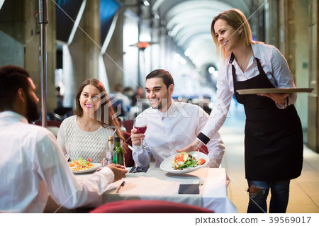 waitress bringing order at terrace table in summer day waitress bringing order at terrace table in summer day 39569017