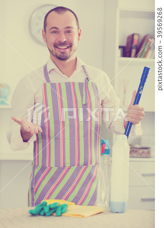 Young man in apron cleaning table Young man in apron cleaning table 39569268
