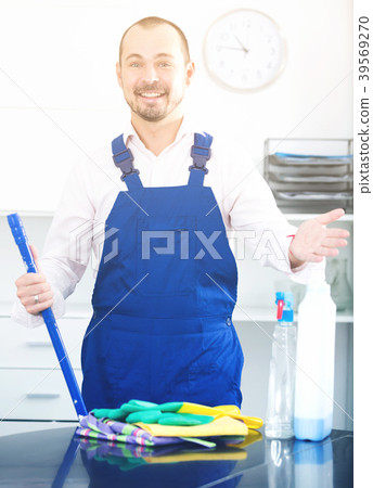 Young man in apron cleaning table Young man in apron cleaning table 39569270