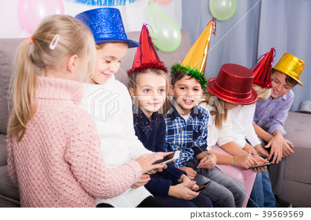 children happy to play with mobile phones together at dinner children happy to play with mobile phones together at dinner 39569569