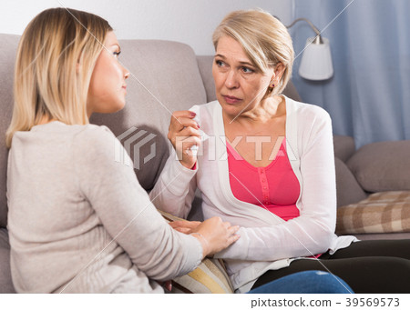 daughter comforts a sad mother 39569573