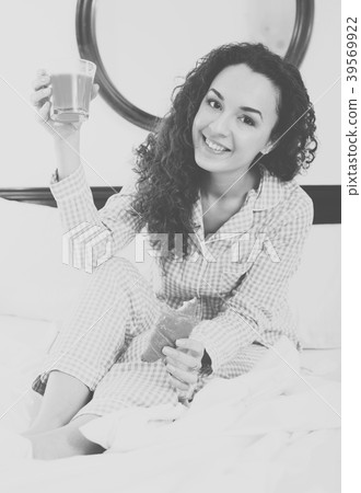 Adult girl eating pastry and juice in bed Adult girl eating pastry and juice in bed 39569922