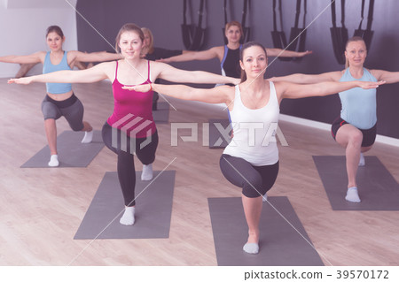 Women exercising yoga poses in fitness center Women exercising yoga poses in fitness center 39570172