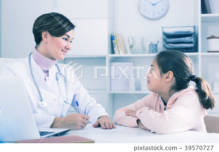 Doctor fills patient card for girl Doctor fills patient card for girl 39570727