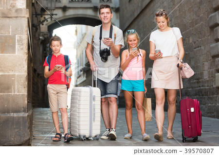 Joyful family with kids busying with phones 39570807