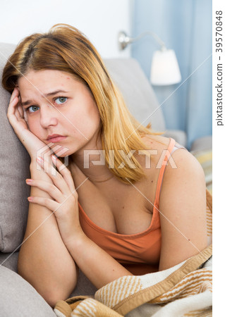 sad female on cozy sofa at home 39570848