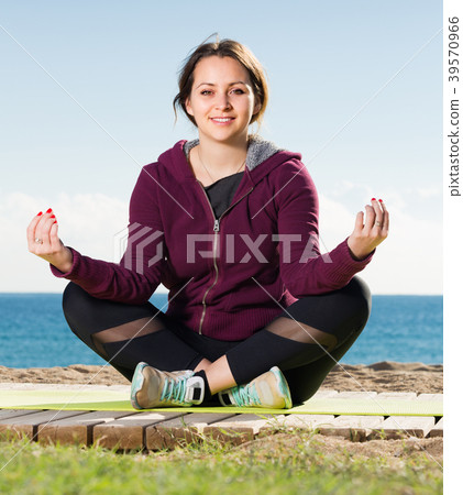 Glad adult girl exercising on exercise mat 39570966