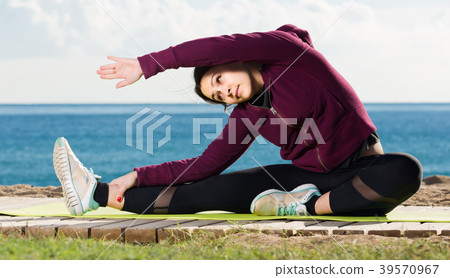 girl exercising on exercise mat outdoor 39570967