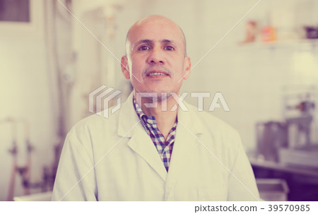 Middle aged worker standing near the table 39570985