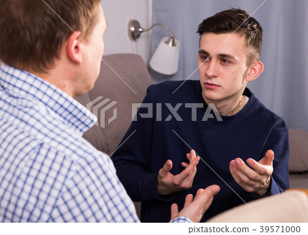 Sad guy with his father are resting and talking about teenage life 39571000