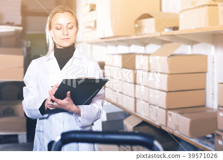 Young woman worker standing with notepad Young woman worker standing with notepad 39571026