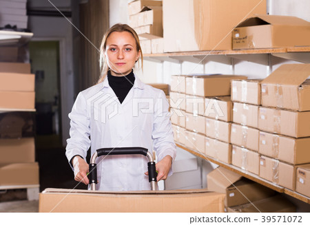 Woman standing in production workshop with boxes 39571072