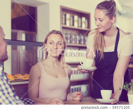 waiter girl brought cup of coffee for couple of different aged cheerful people waiter girl brought cup of coffee for couple of different aged cheerful people 39571105