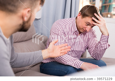Man discussing problems with friend on sofa 39571229