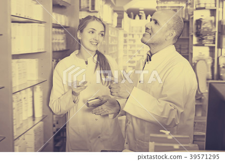 Professional pharmacist standing at pay desk Professional pharmacist standing at pay desk 39571295
