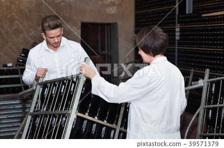Male worker transporting wine bottles to storage Male worker transporting wine bottles to storage 39571379