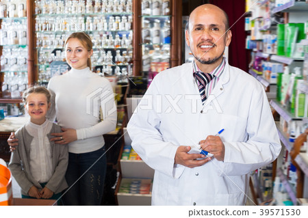 Pharmacist standing next to shelves 39571530