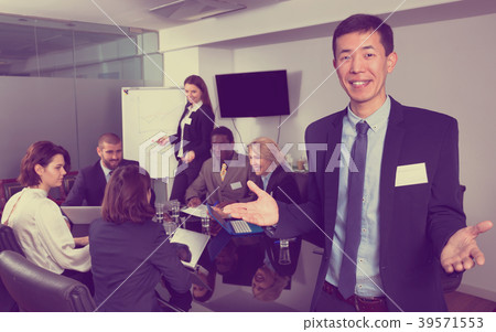 Successful business group with smiling Korean man foreground in meeting room Successful business group with smiling Korean man foreground in meeting room 39571553
