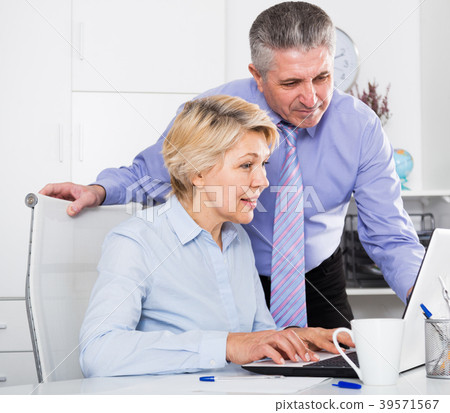 Mature man helping his colleague Mature man helping his colleague 39571567