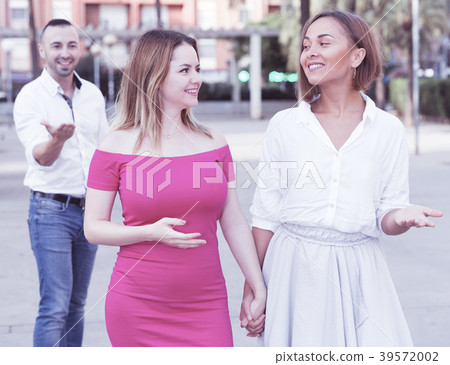 Young women are walking and stranger man is want acquaintance with them 39572002