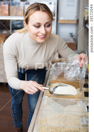 Woman selecting groats in store 39572044